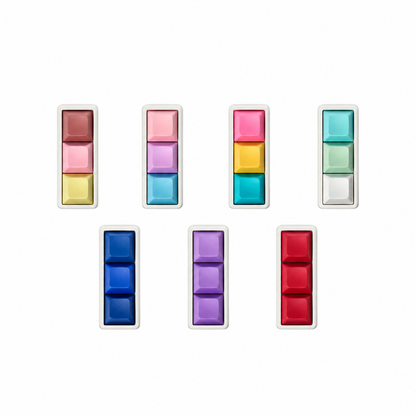 Top view of seven Mini 3-key keyboard fidgets with white bases in Peach Sorbet, Daydream, Electric Splash, Sea Breeze, Blue, Lavender, and Red.