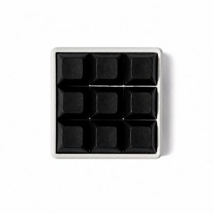 The Original 9-key square fidget with solid black keycaps on a white base.