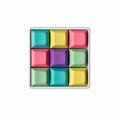 The Original 9-key square fidget with cyan, yellow, pink, lavender, and mint green keycaps on a white base.