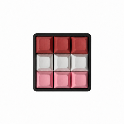 The Original 9-key square fidget with terracotta, white, and pink keycaps on a black base.