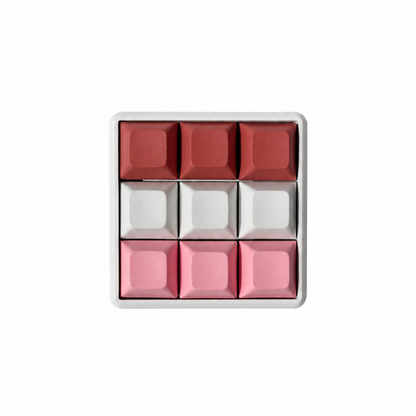The Original 9-key square fidget with terracotta, white, and pink keycaps on a white base.