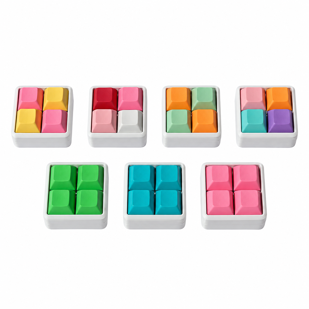 Angled view of seven Pocket 4-key square keyboard fidgets with white bases in different keycap color combinations.
